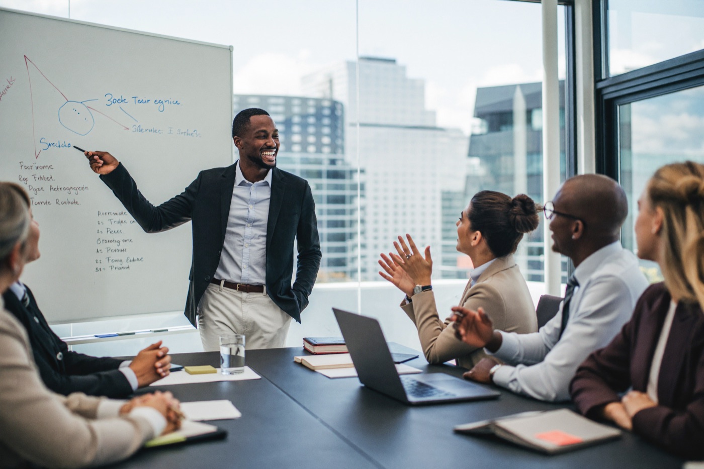 A leader coaching a diverse team at a whiteboard